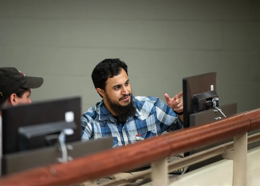 student discussing project on computer in a computer lab