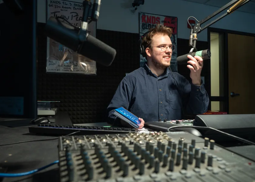student running a podcast and working in the sound studio