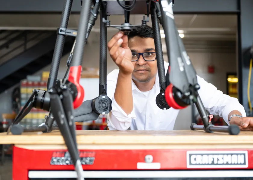 faculty member adjusts setting on a drone